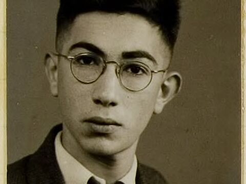 Passfpoto eines jungen Mannes mit Brille, der ernst in die Kamera blickt.