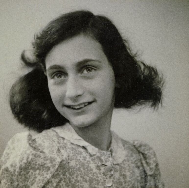 Porträtfoto von Anne Frank als Jugendliche in schwarz-weiß, sie lächelt in die Kamera.